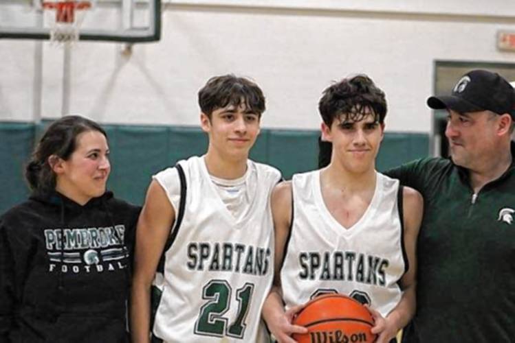 Pembroke Academy senior guard Joe Fitzgerald (second from right) celebrates with his family after scoring his 1,000th career point on Friday night in a 77-45 win over Kennett on his home court.