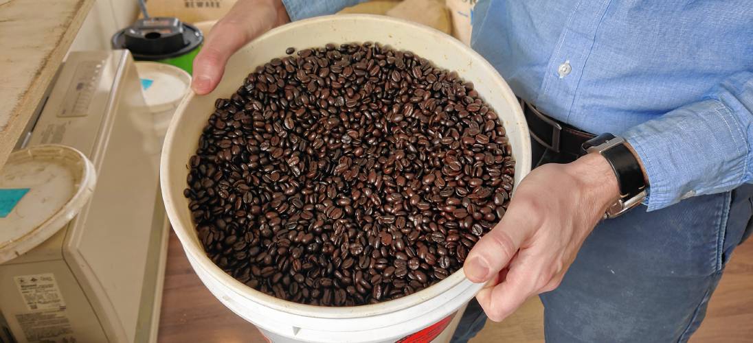  Mason Parker displays a container of roasted coffee beans.