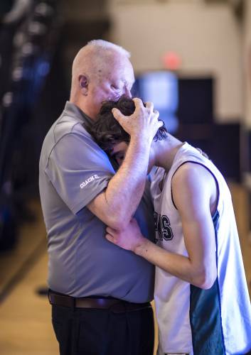 Pembroke coach Mike Donnell comforts guard Mike Strazzeri after Pelham defeated the Spartans in Division II championship on March 12 at Lundholm gym in Durham. 