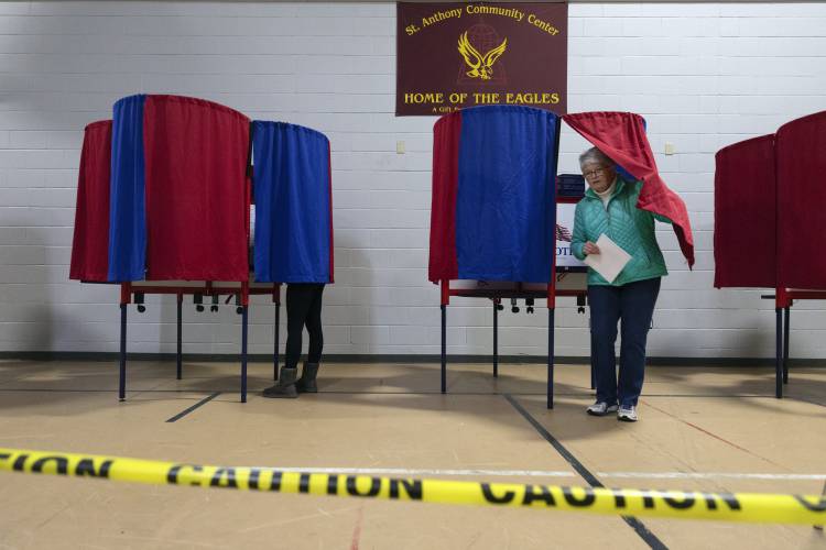 A voter leaves a polling booth at St. Anthony Community Center during the presidential primary election, Tuesday, Jan. 23, 2024, in Manchester, N.H. (AP Photo/Michael Dwyer)