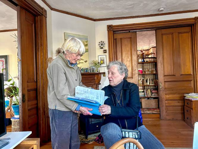 Barbara Filion and Linda Albertson Thorpe sort through medical bills.