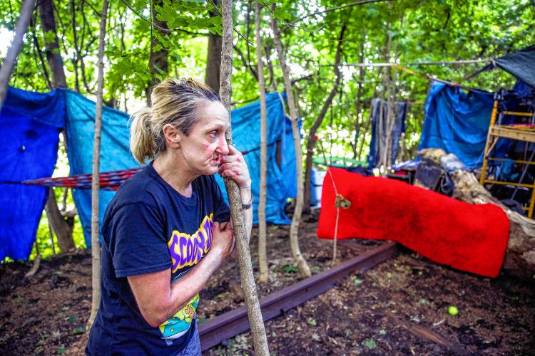 A woman named Melissa, who did not want her last name used for fear of her safety, stands in front of her homeless camp on the railroad tracks in the back of Robin Bach’s home on North Main Street in Concord on Wednesday. Melissa read about how Bach’s children wouldn’t play in the backyard of their 19th-century house in Concord.