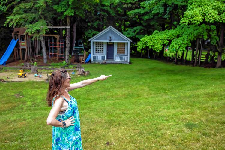 Robin Bach points to the woods in her Concord backyard where two homeless camps are located on June 19. Her children do not play in the backyard because of the camps.