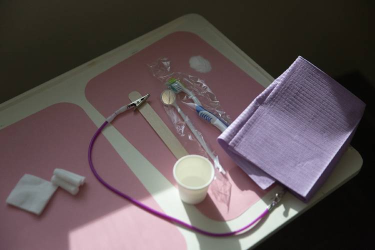A toothbrush, mirror and cotton swabs sit on a tray ready for the next patient during a free dental clinic at the Vermont Agency of Human Services Hartford District Office Building in White River Junction, Vt., on Feb. 9.