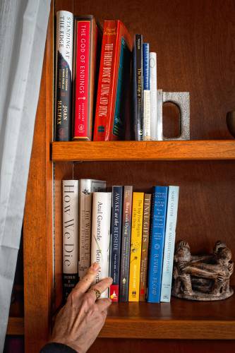 Books about death and dying sit on a shelf. Books about death and dying sit on a shelf.