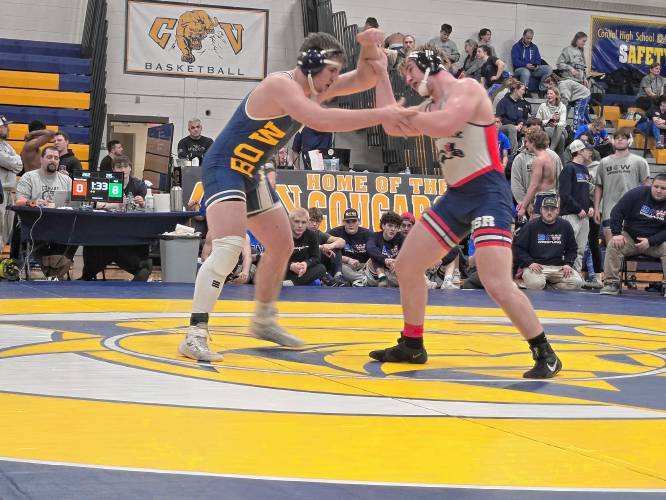 Bow’s Jackson Hall (left) grapples with John Stark’s Alex Descoteau (right) during the 215-pound final at the Division III wrestling championship on Saturday. Hall won the 215 title to help Bow defend its team championship.