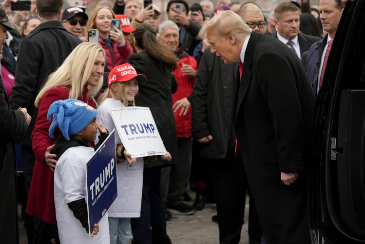 Republican presidential candidate former President Donald Trump, right, and Rep. Marjorie Taylor Greene, R-Ga., left, greet young supporters at a campaign stop in Londonderry, N.H., Tuesday, Jan. 23, 2024. (AP Photo/Matt Rourke)