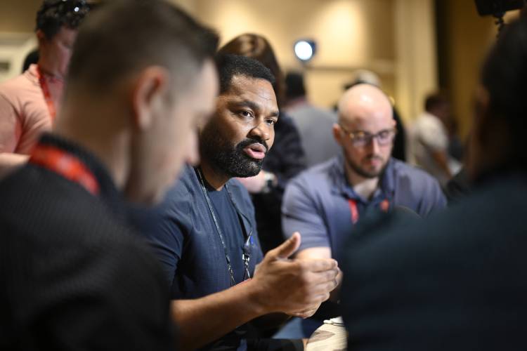 New England Patriots head coach Jerod Mayo, center, talks with reporters during an AFC coaches availability at the NFL owners meetings last March in Orlando, Fla.