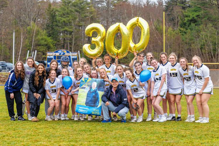 Bow girls’ lacrosse players celebrate with Chris Raabe on her 300th career win after the team defeated Bishop Brady, 19-2, on Wednesday.