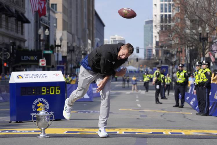 Former New England Patriots NFL football player Rob Gronkowski spikes a football on the finish line at the Boston Marathon, Monday, April 15, 2024, in Boston. Gronkowski is grand marshal of the race. (AP Photo/Steven Senne)