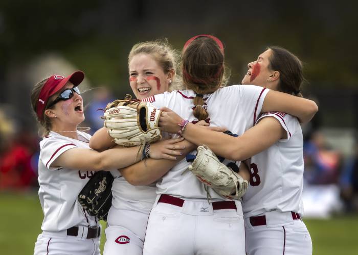 FILE – Concord pitcher Maddy Wachter (second from left is hugged by teammates Sarah Taylor (8), Brooke Wyatt (7) as Lily Hacket (left) rushes in after the Tide won the 2023 softball championship on June 10. Wachter picked up where she left off to open the 2024 season, striking out 17 in a complete-game effort as Concord defeated Windham, 9-3, on Tuesday.