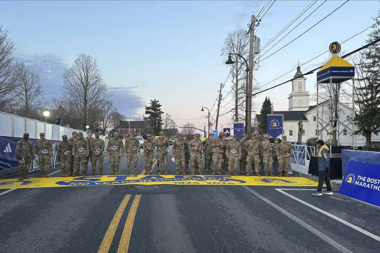 Boston Marathon Race Director Dave McGillivray, right, sends a group of Massachusetts National Guard members across the start line in Hopkinton on Monday, April 15, 2024 to begin the marathon. The start line was painted in honor of the town that has hosted the marathon for the past century. It's the 128th edition of the world’s oldest and most prestigious annual marathon. (AP Photo/Jennifer McDermott)