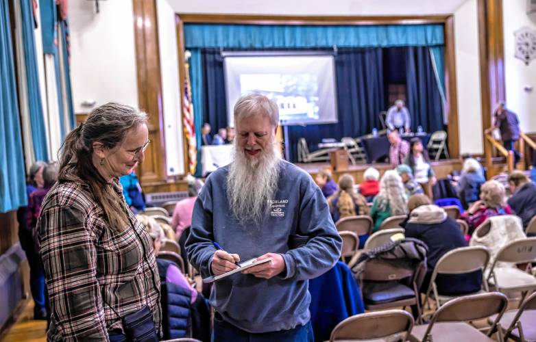 Mary and Dan Watts look over the Warner annual report before town meeting on Wednesday, March 12, 2025.
