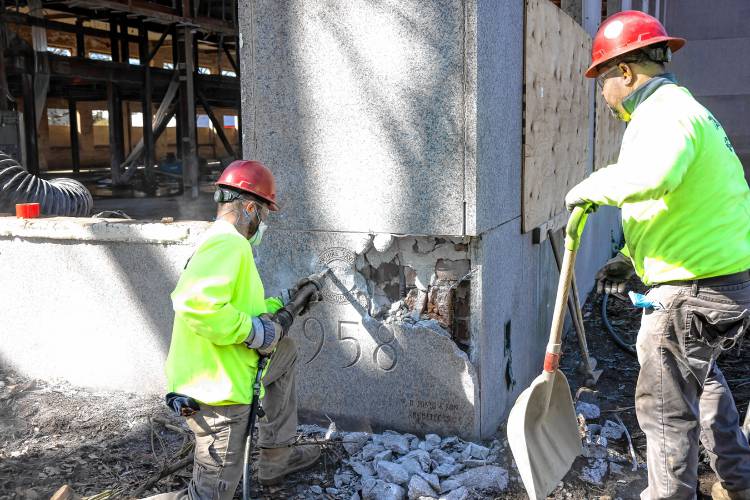 A member of the S&R Demolition team out of Lowell, Massachusetts use an hammer to chip away at the cornerstone of the former DOJ and Mechanics Bank building on North State Street as they search for the time capsule on Tuesday, April 9, 2024.